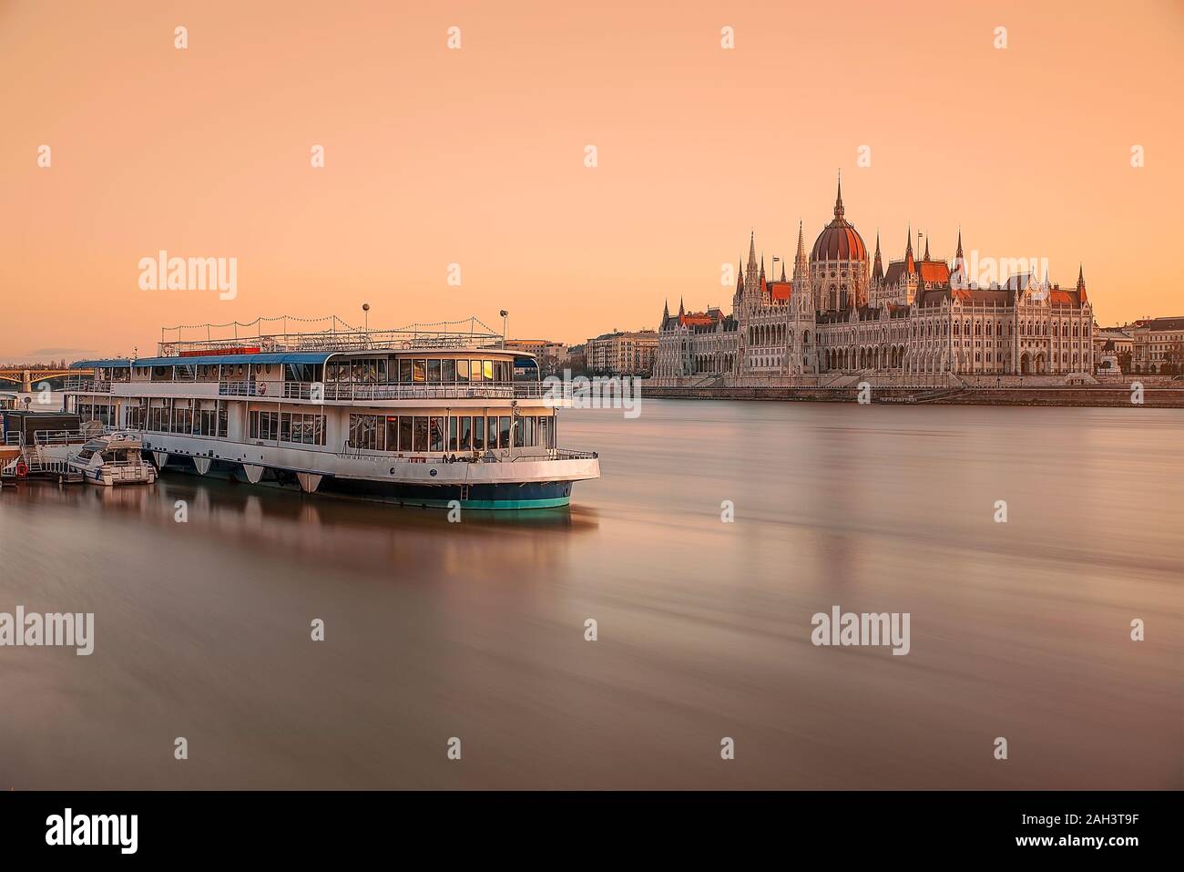 Parlamento ungherese e barca. Mattina Amazind luci con acqua sfocata. Crociera in barca, una lunga esposizione, fiume Danubio Foto Stock