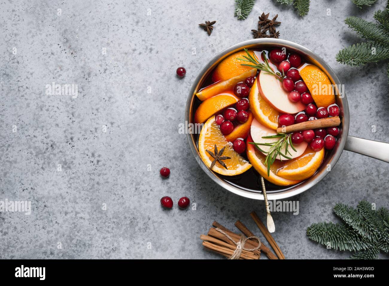 E anice stellato sulla tavola nera con abete rami. Natale vin brulé con cannella, arancione e albero in pietra grigia tabella. Tradizione invernale d Foto Stock