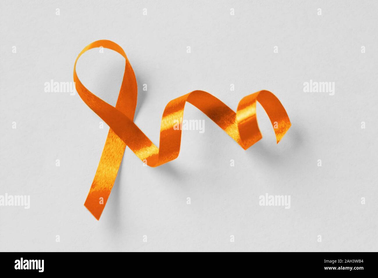 Nastro arancione su sfondo bianco - Concetto di consapevolezza di leucemia, cancro del rene associazione, la sclerosi multipla e l'abuso di animali Foto Stock