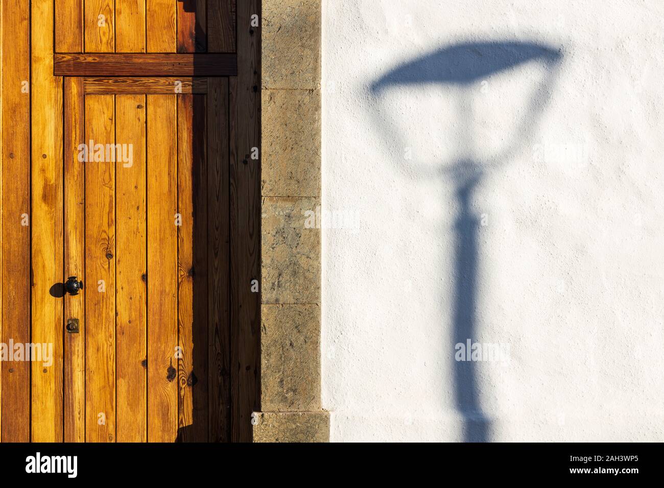 Lampost ombra da una porta di legno nel villaggio di La Quinta, Adeje, Tenerife, Isole Canarie, Spagna, Foto Stock