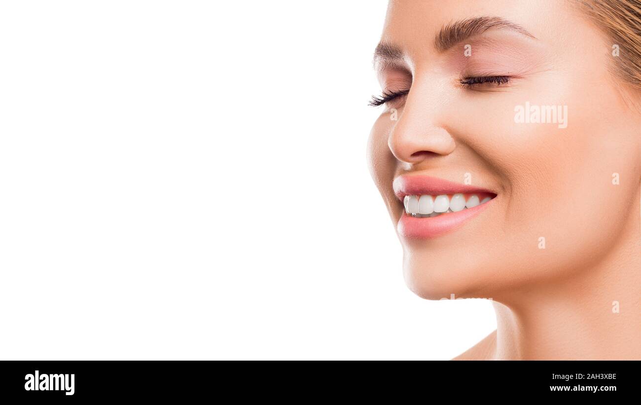 Close up ritratto di una donna sorridente su bianco backgrouns. Salute dentale e sbiancamento dei denti del concetto. Foto Stock