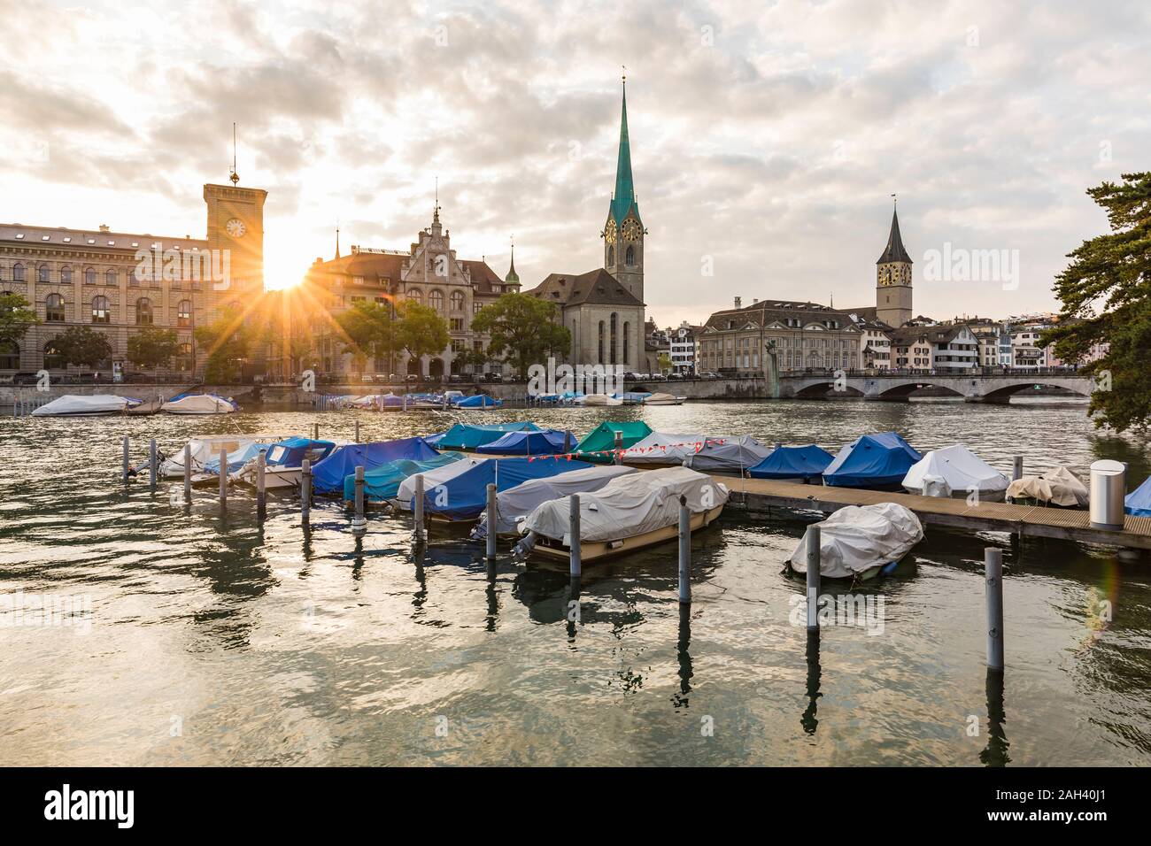 La Svizzera, nel Cantone di Zurigo, Zurigo, coperto barche ormeggiate sul fiume Limmat al tramonto con old town waterfront in background Foto Stock