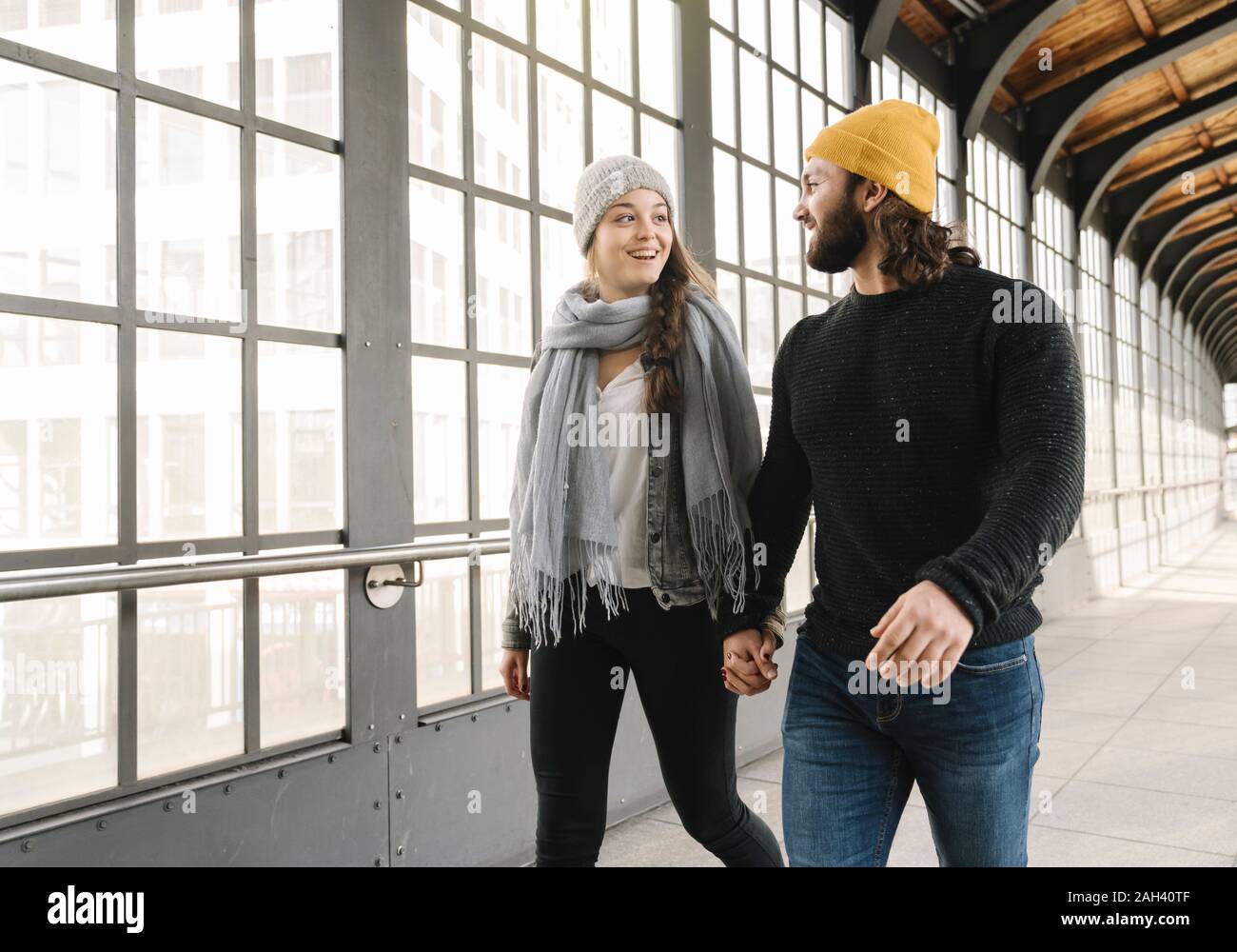 Felice coppia giovane camminando mano nella mano a una stazione della metropolitana di Berlino, Germania Foto Stock