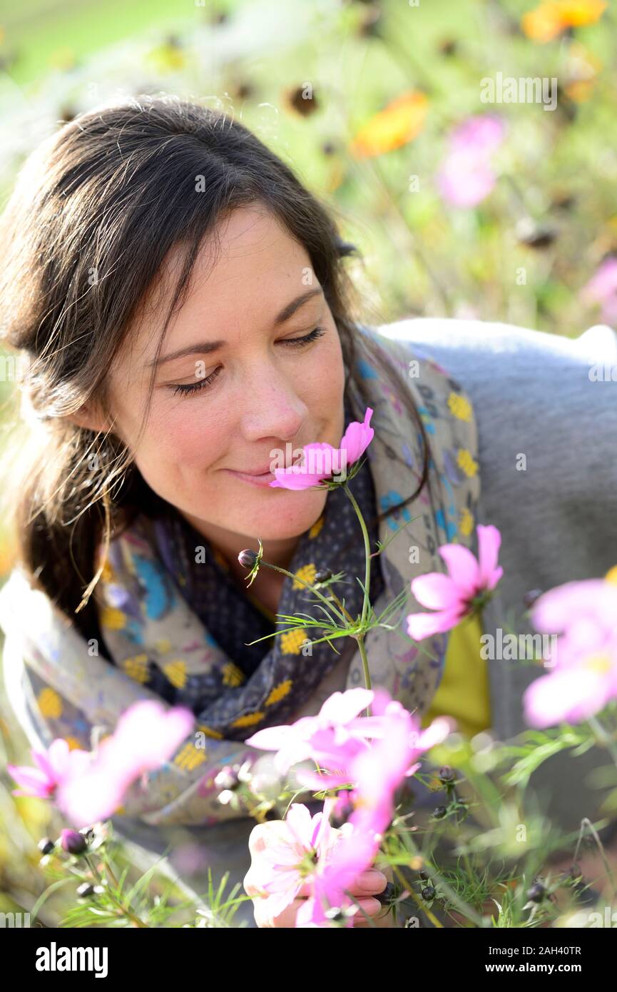 Ritratto di donna annusare il fiore selvatico, fiore prato Foto Stock