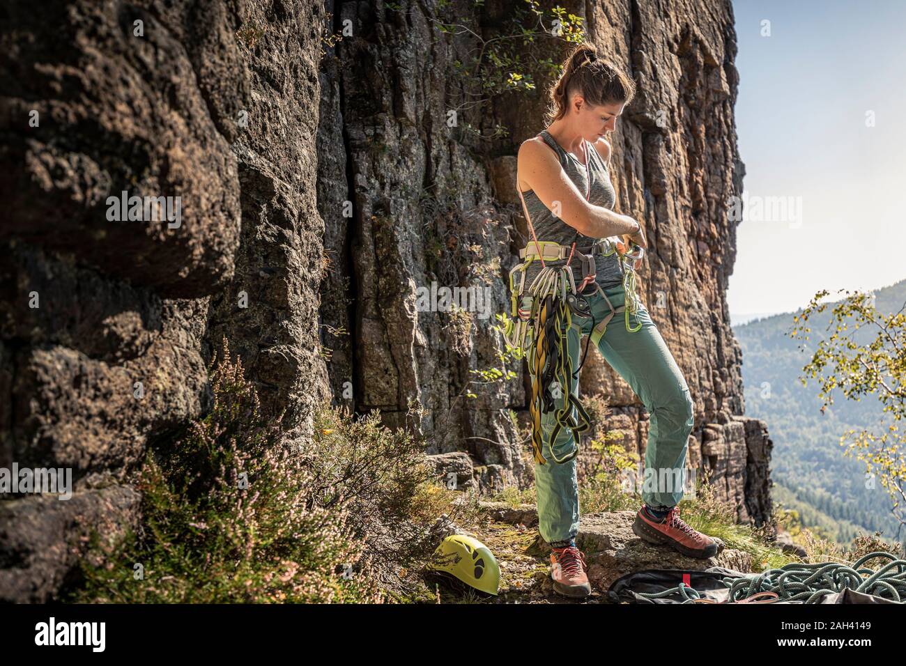 La donna si prepara a salire, mettendo sul cablaggio di arrampicata Foto Stock