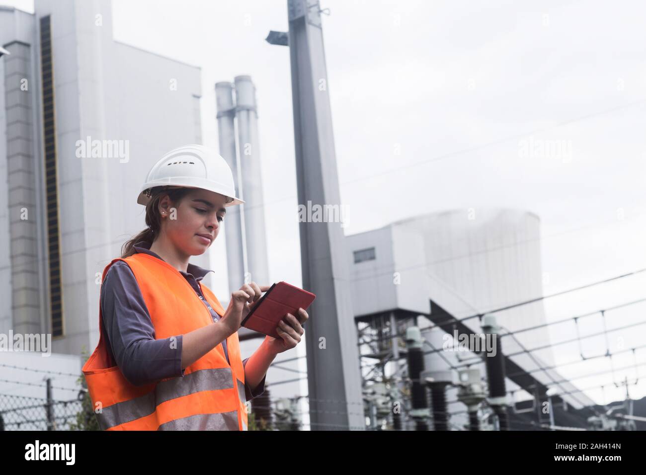 Lavoratore di sesso femminile che utilizzano tablet a impianto di alimentazione Foto Stock