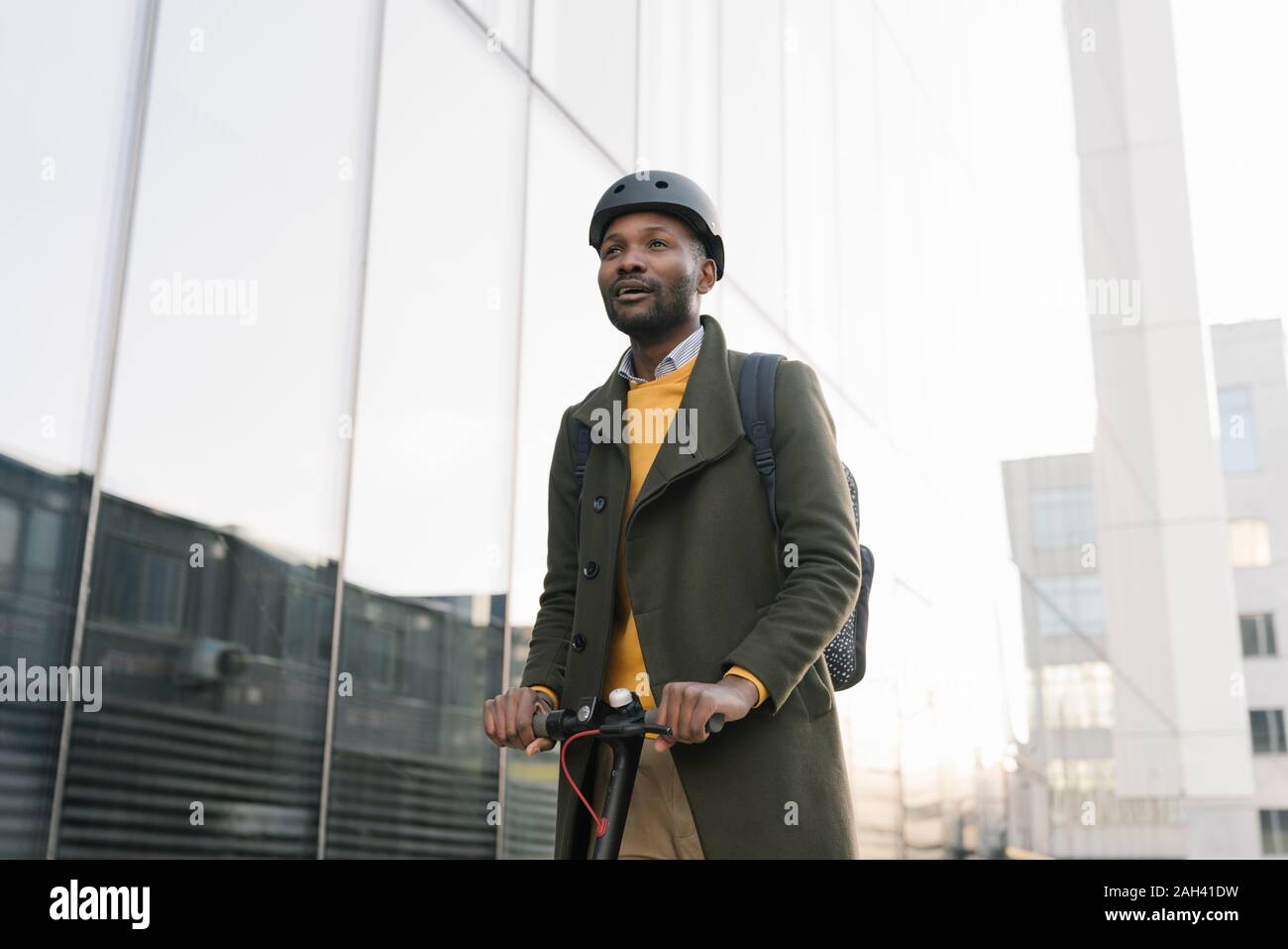 Ritratto di elegante uomo con casco e scooter in città Foto Stock