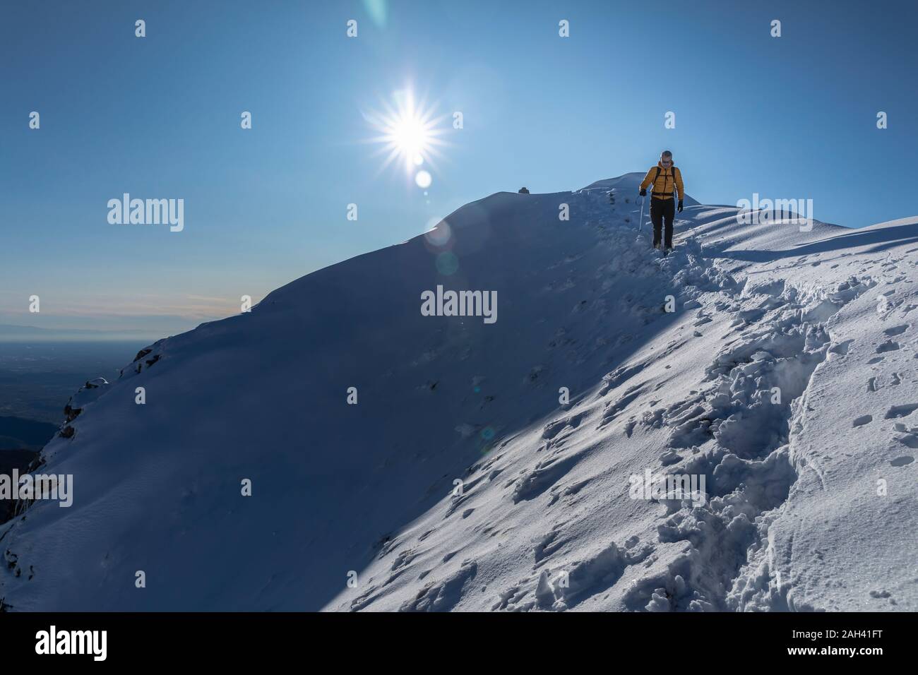 Alpinista escursionismo sulla montagna innevata, Lecco, Italia Foto Stock