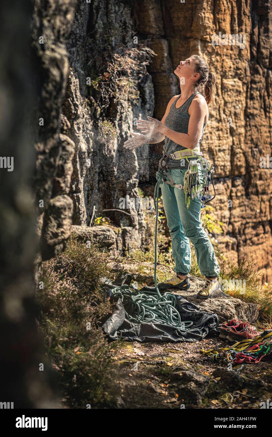 La donna si prepara a salire, guardando in alto sulla parete di arrampicata Foto Stock