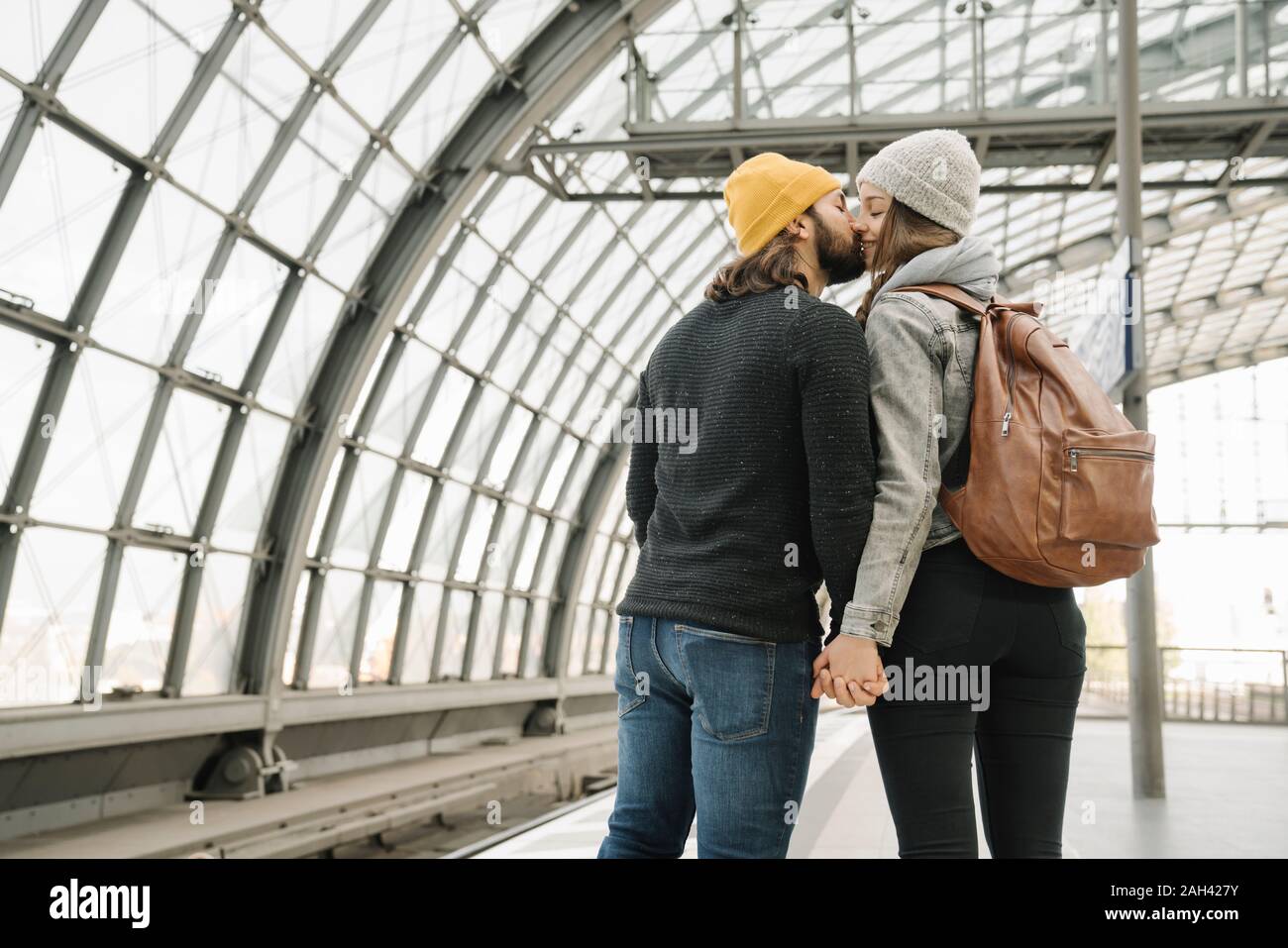 Coppia giovane kissing alla piattaforma della stazione, Berlino, Germania Foto Stock