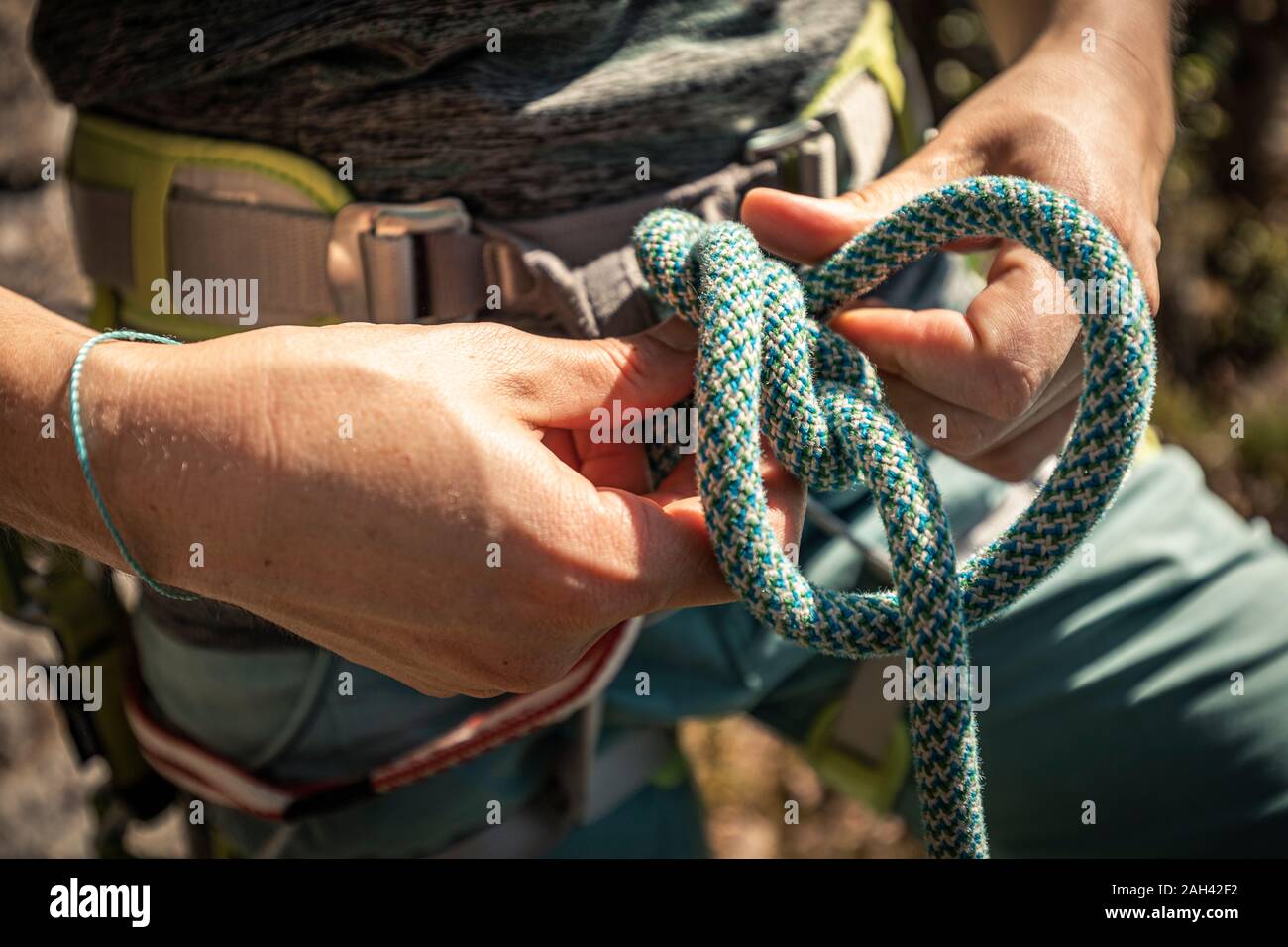 La donna si prepara a salire, controllo di corda, figura 8 nodo Foto Stock