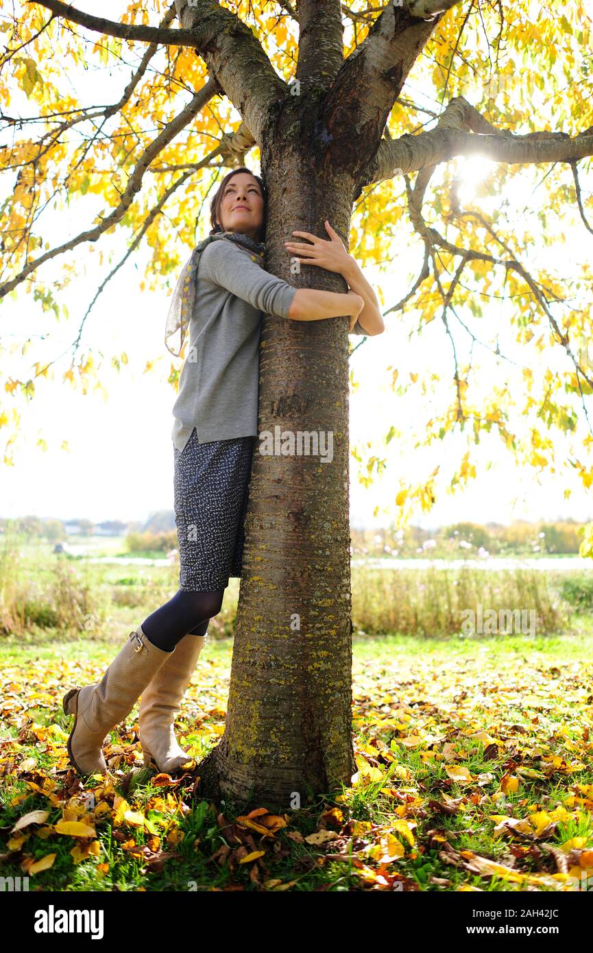 Ritratto di donna abbracciando ad albero Foto Stock