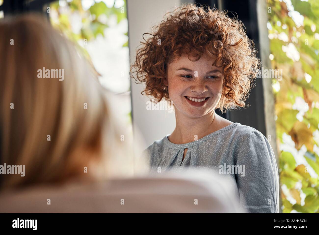 Ritratto di sorridere redheaded imprenditrice in office Foto Stock