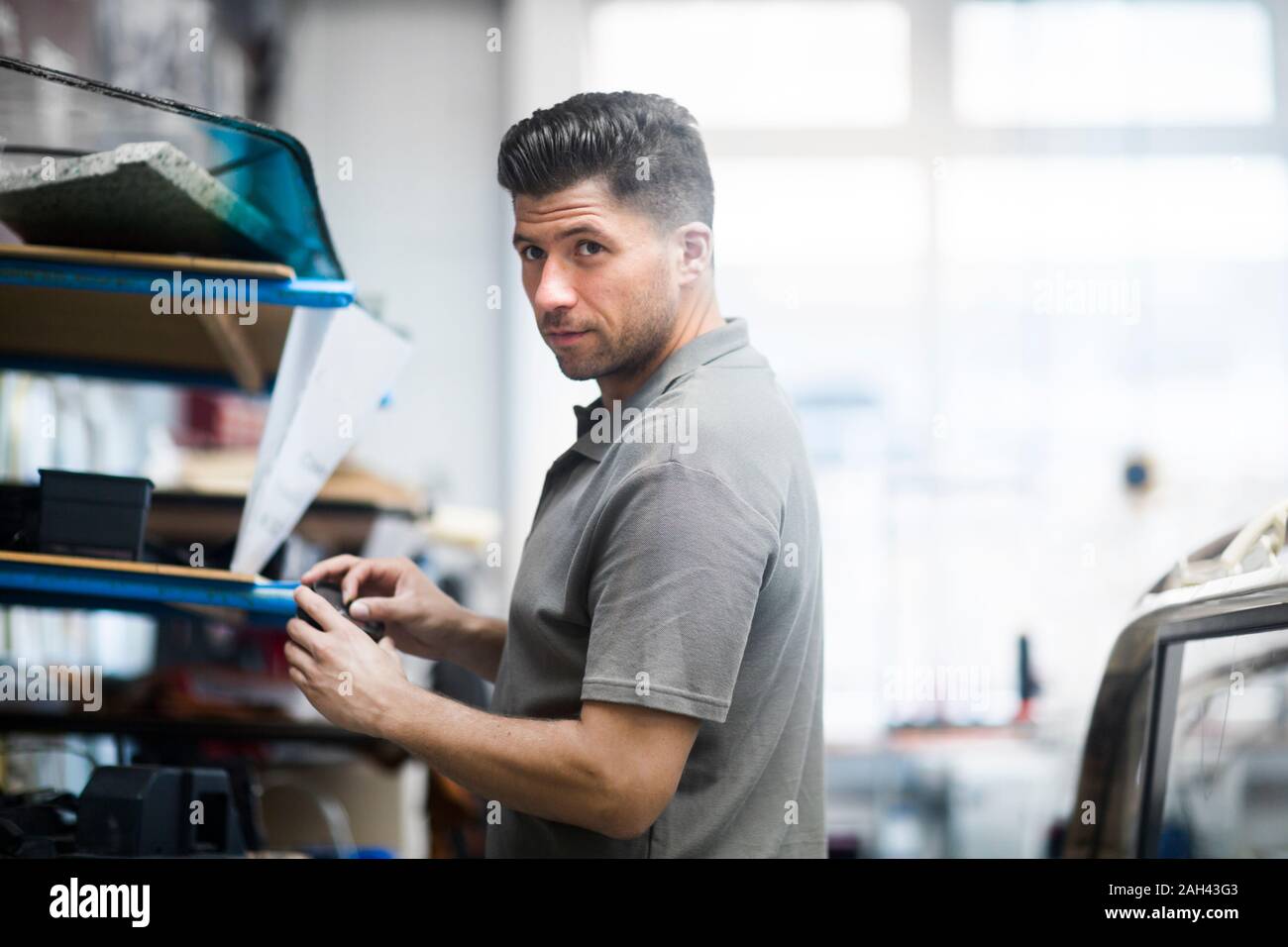 Giovane uomo che lavora in una officina di tappezzeria Foto Stock
