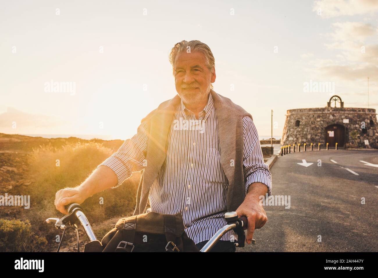L'uomo anziano in bicicletta al tramonto, Tenerife Foto Stock