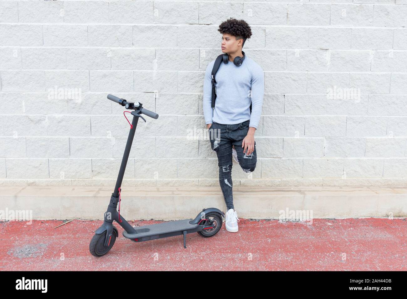 Giovane uomo con e-scooter all'aperto Foto Stock