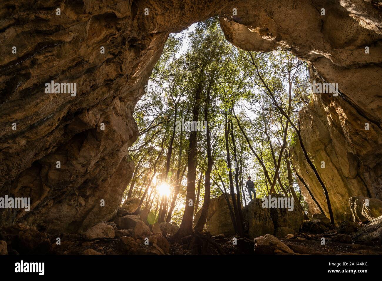Donna in uscita di una grotta in controluce, Finale Ligure, Liguria, Italia Foto Stock