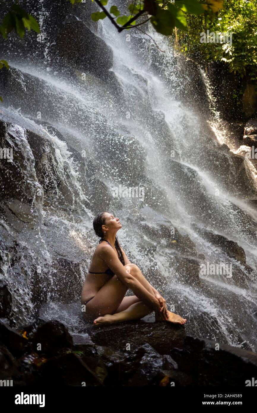 Giovane donna vicino Kanto Lampo cascata, Bali, Indonesia Foto Stock
