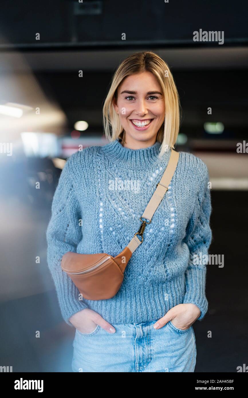 Ritratto di un felice giovane donna in un garage di parcheggio Foto Stock