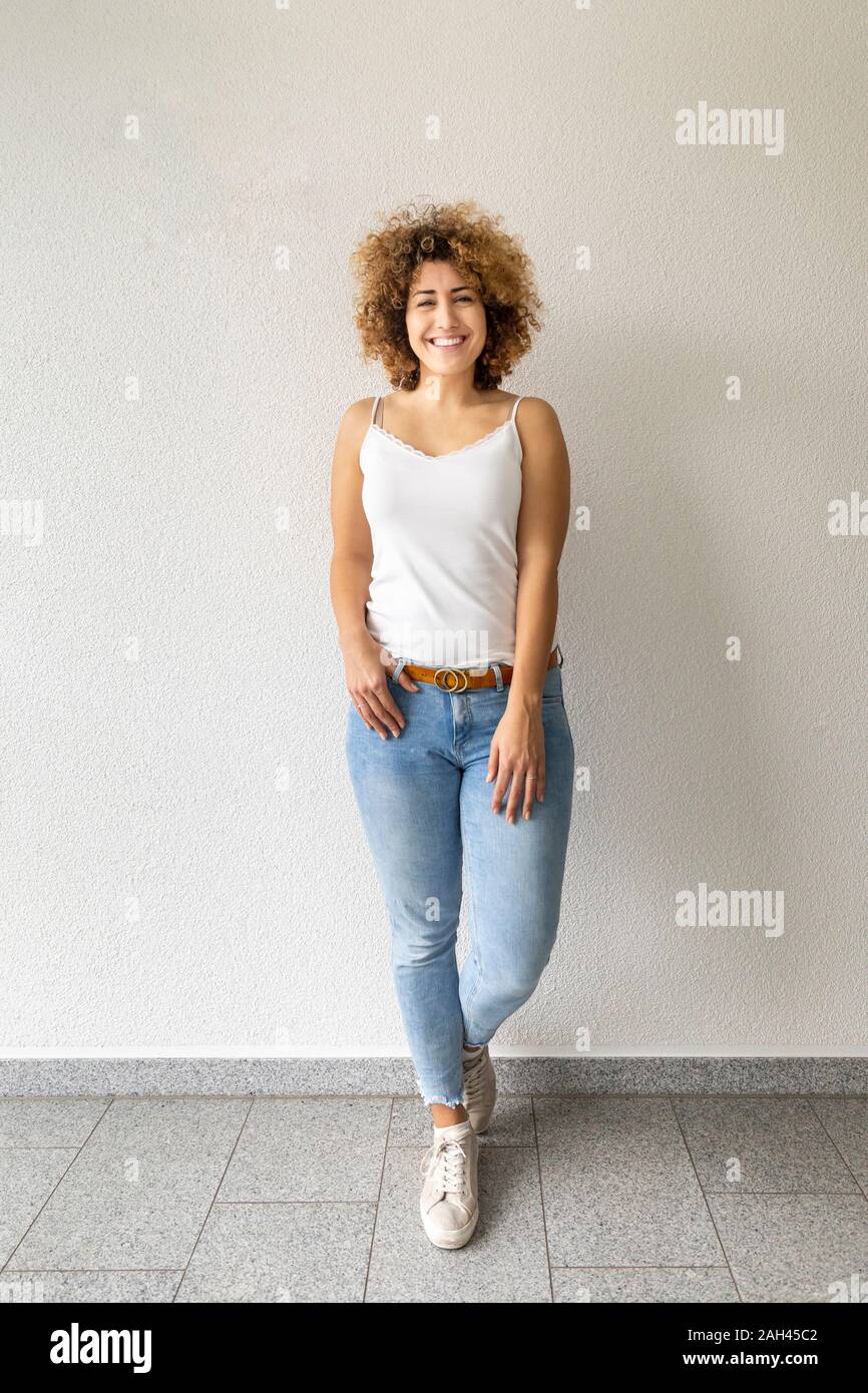 Sorridente metà donna adulta che indossa jeans Foto Stock