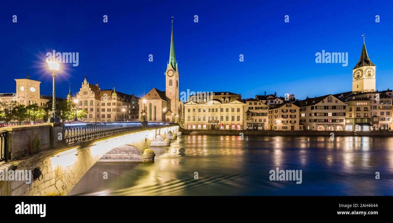 La Svizzera, nel Cantone di Zurigo, Zurigo, fiume Limmat e città vecchia edifici lungo illuminato Limmatquai street al crepuscolo Foto Stock