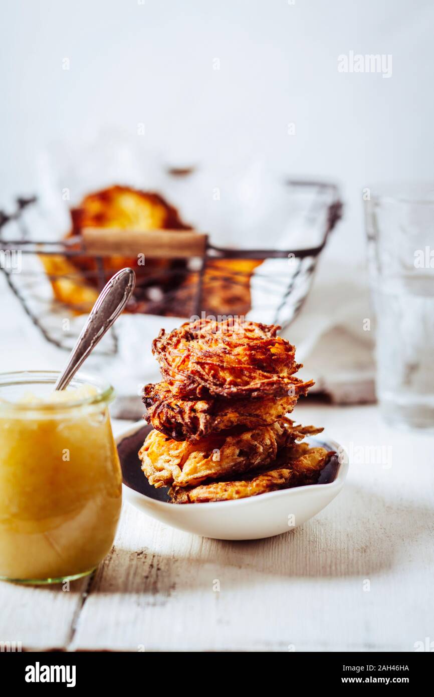 Un vasetto di salsa di mele e una ciotola di croccante latkes ebraica Foto Stock