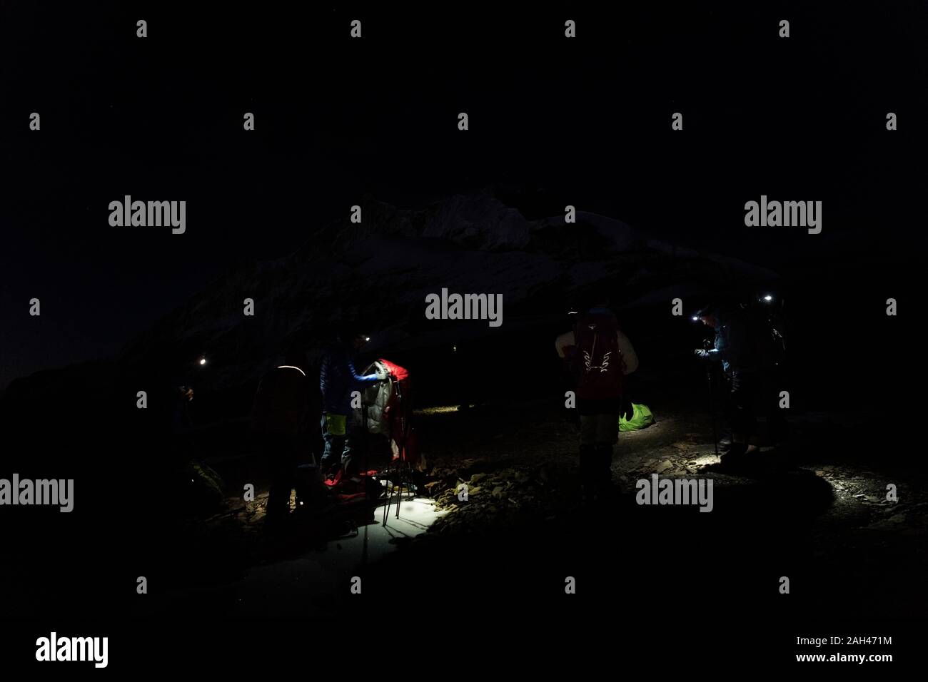 Gli alpinisti con proiettori preparazione di notte, Circuito Dhaulagiri Trek, Himalaya, Nepal Foto Stock
