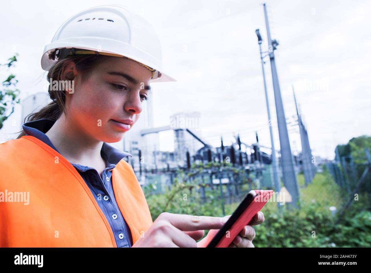 Lavoratore di sesso femminile che utilizzano tablet sul sito industriale Foto Stock