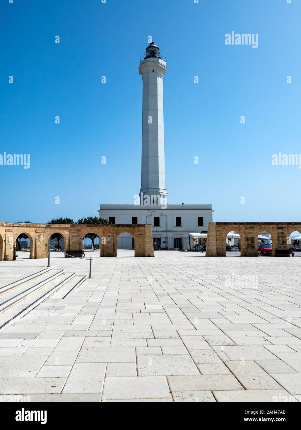 Italia, in provincia di Lecce e Santa Maria di Leuca, alto faro bianco in piedi contro il cielo chiaro Foto Stock