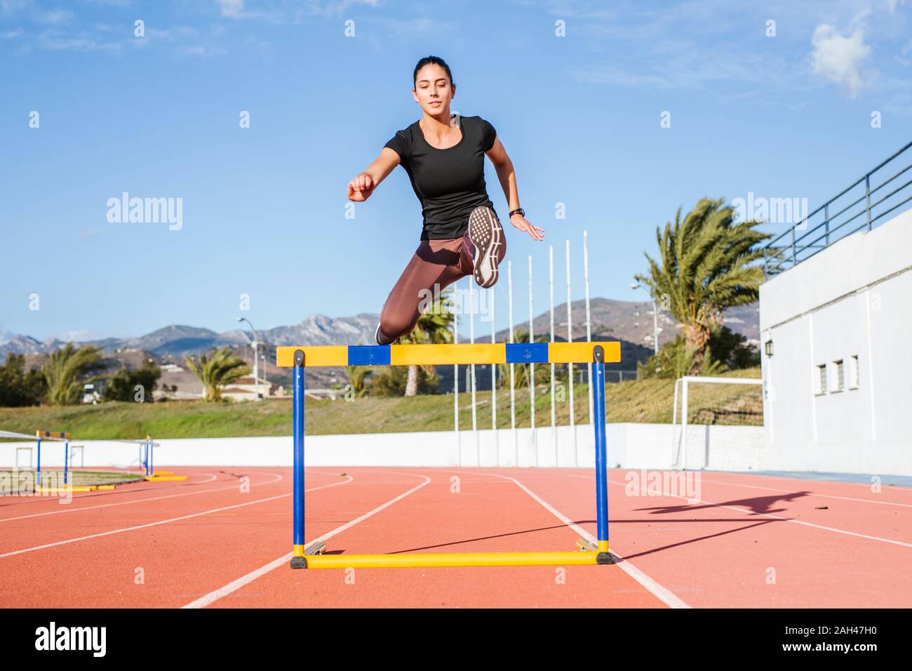 Femmina CENTOMETRISTA A OSTACOLI durante il corso di formazione sulla pista di tartan Foto Stock