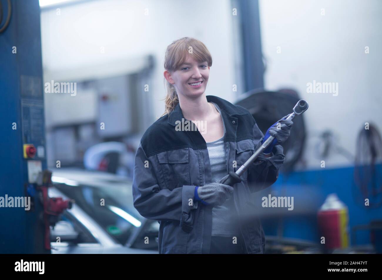 Femmina meccanico auto lavoro in officina di riparazione Foto Stock