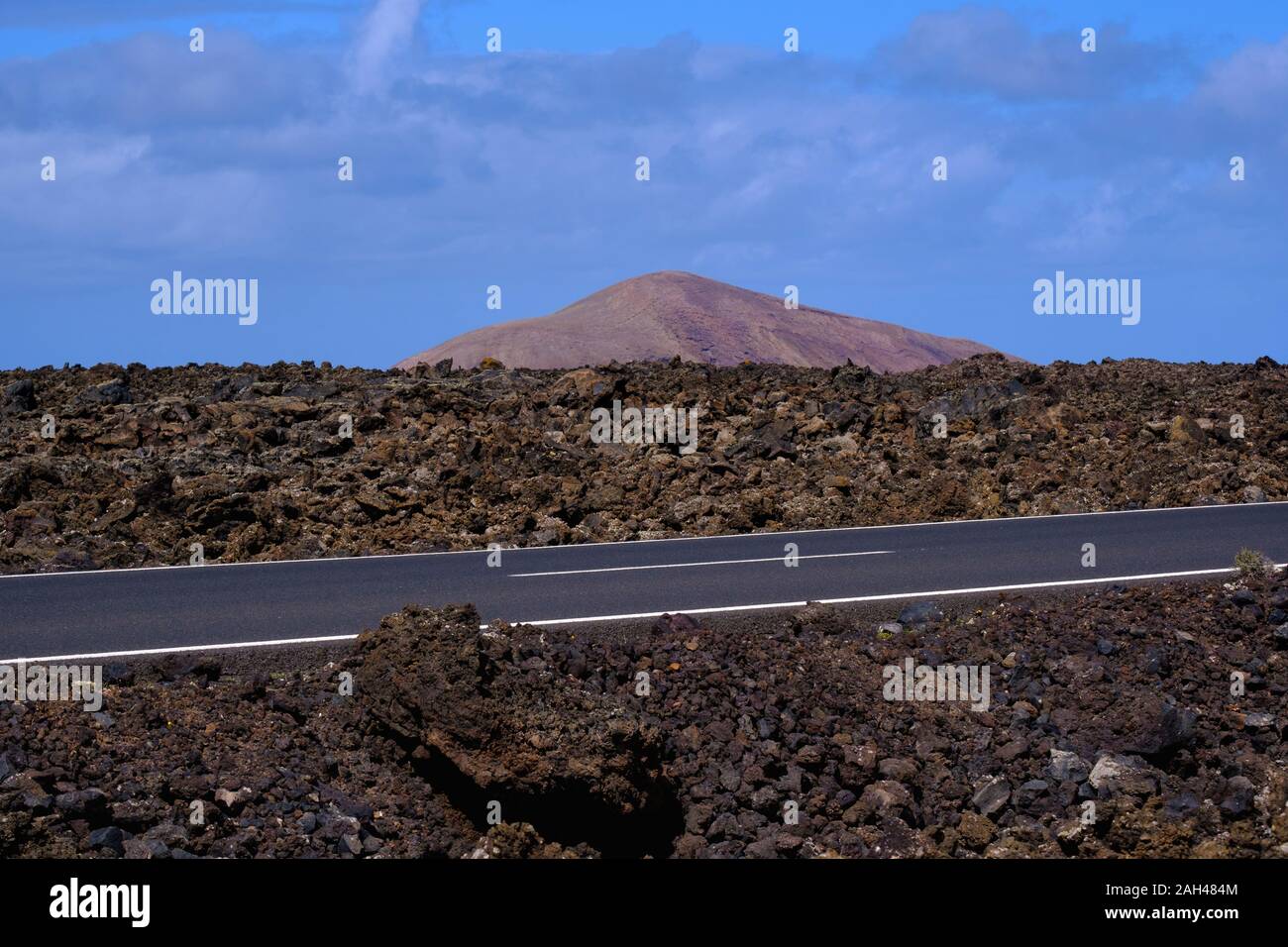Spagna Isole Canarie Lanzarote, Paese strada che attraversa il campo di lava Foto Stock