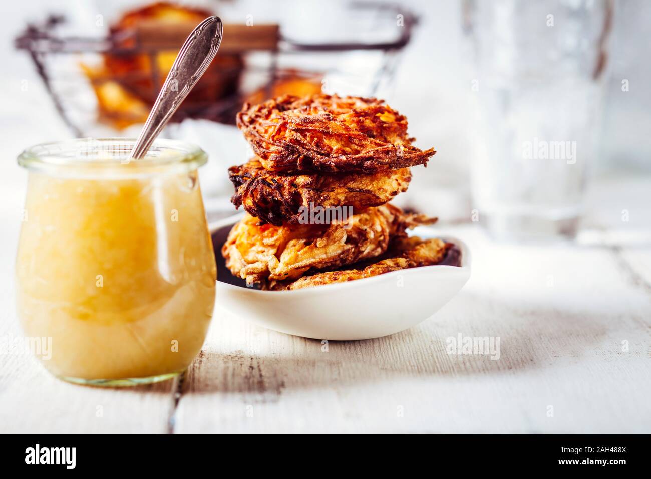 Un vasetto di salsa di mele e una ciotola di croccante latkes ebraica Foto Stock