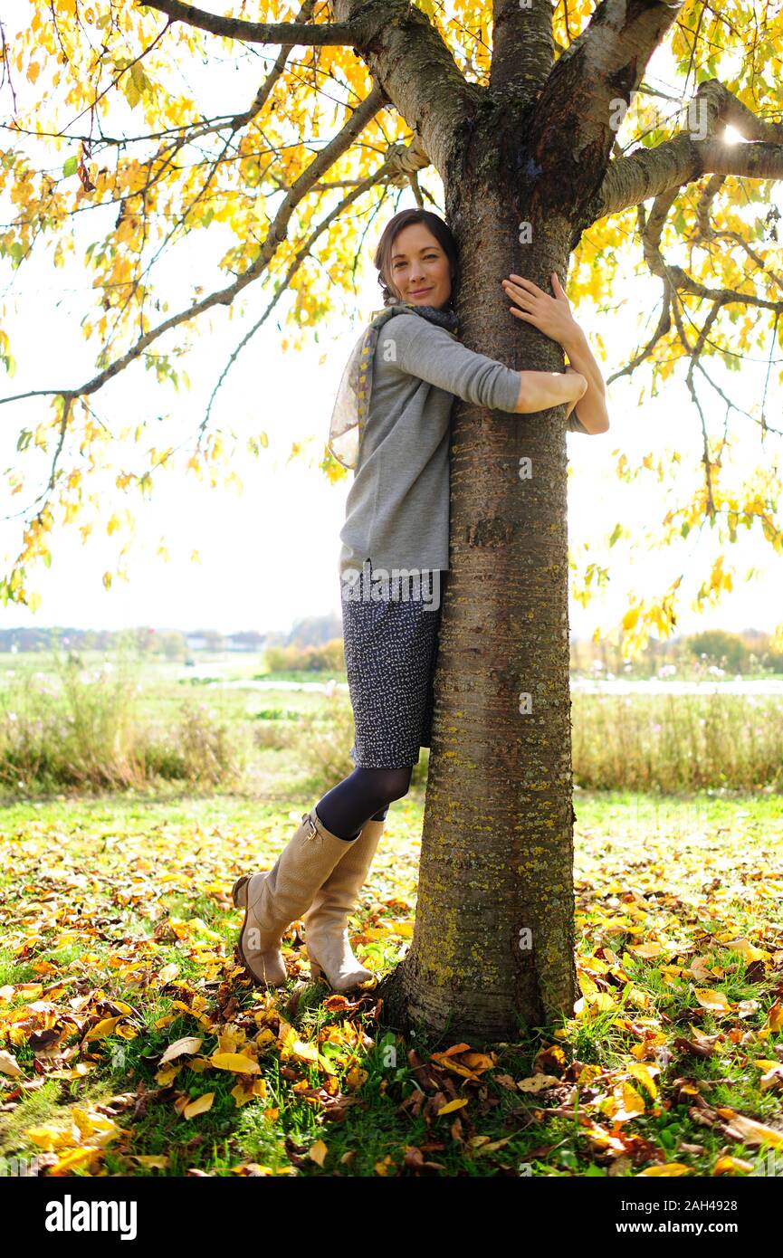 Donna abbracciando ad albero Foto Stock