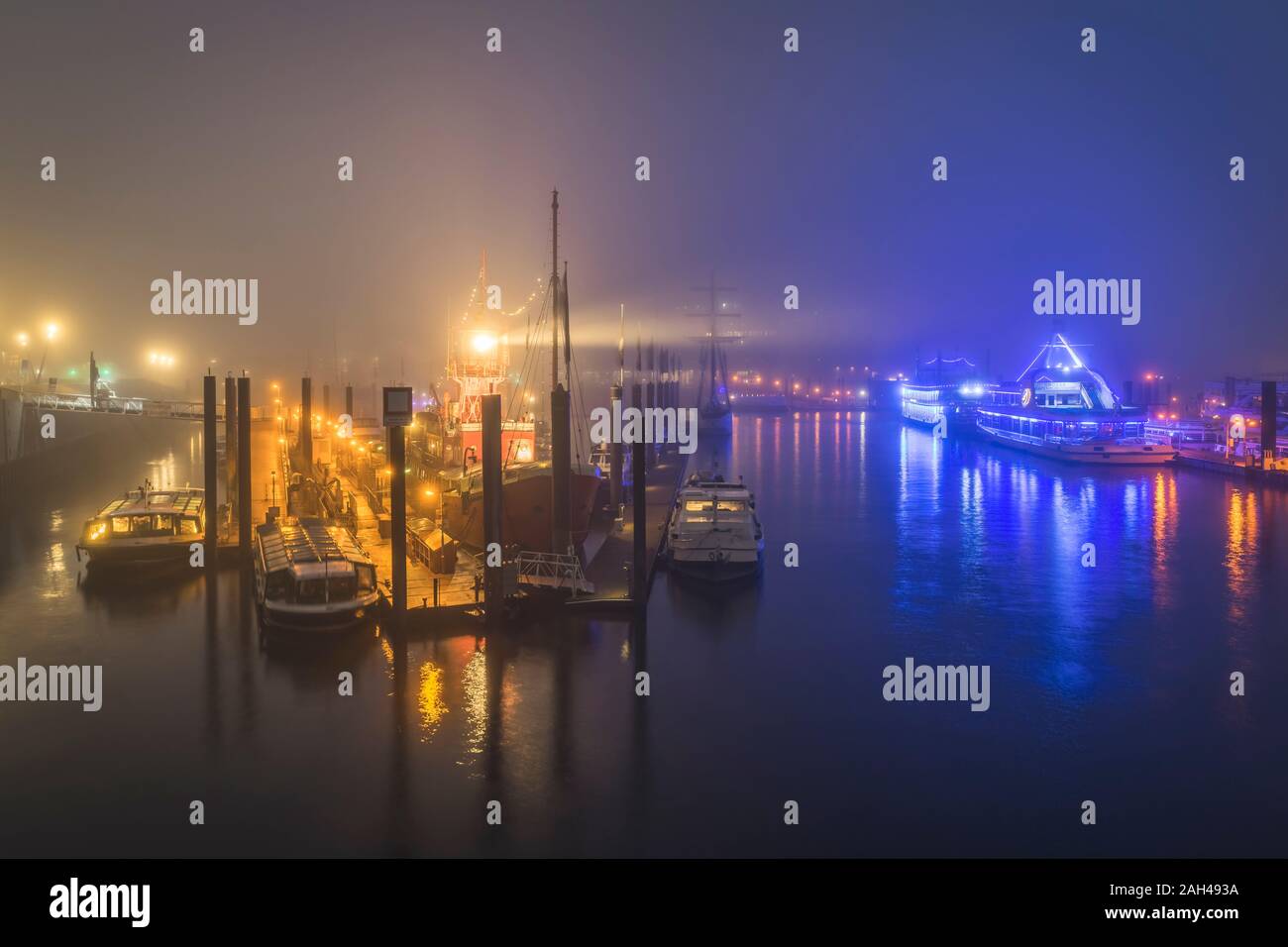 Germania, Amburgo, Hafencity Harbor illuminata sulla notte di nebbia Foto Stock