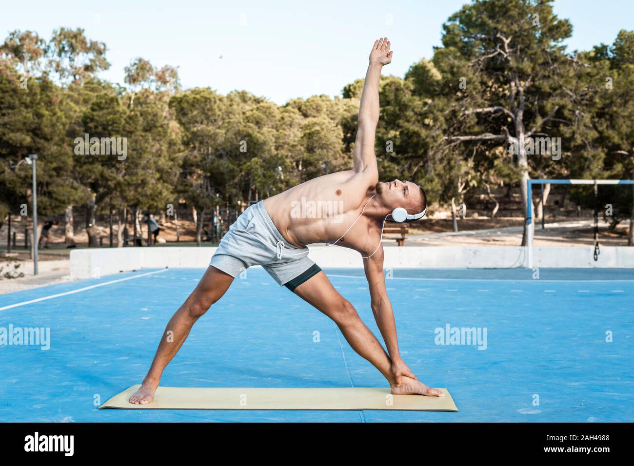 Barechested uomo muscolare praticare esercizi di fitness all'aperto Foto Stock