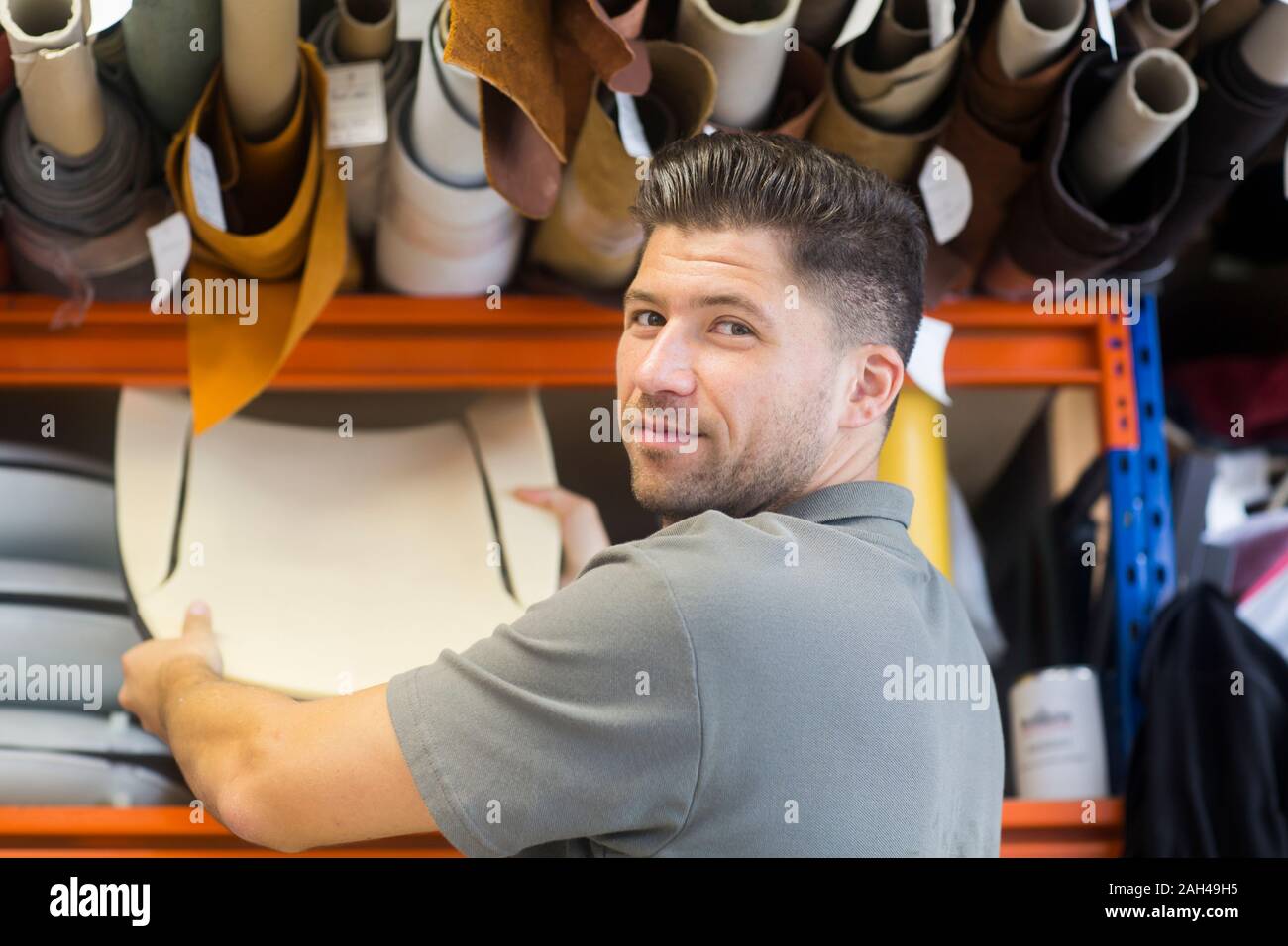 Giovane uomo che lavora in una officina di tappezzeria Foto Stock