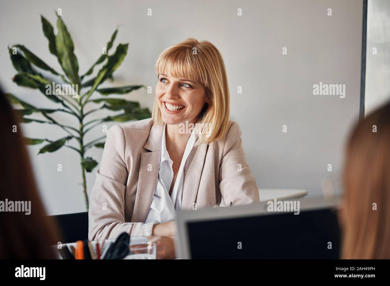 Ritratto di sorridere imprenditrice durante una riunione in ufficio Foto Stock