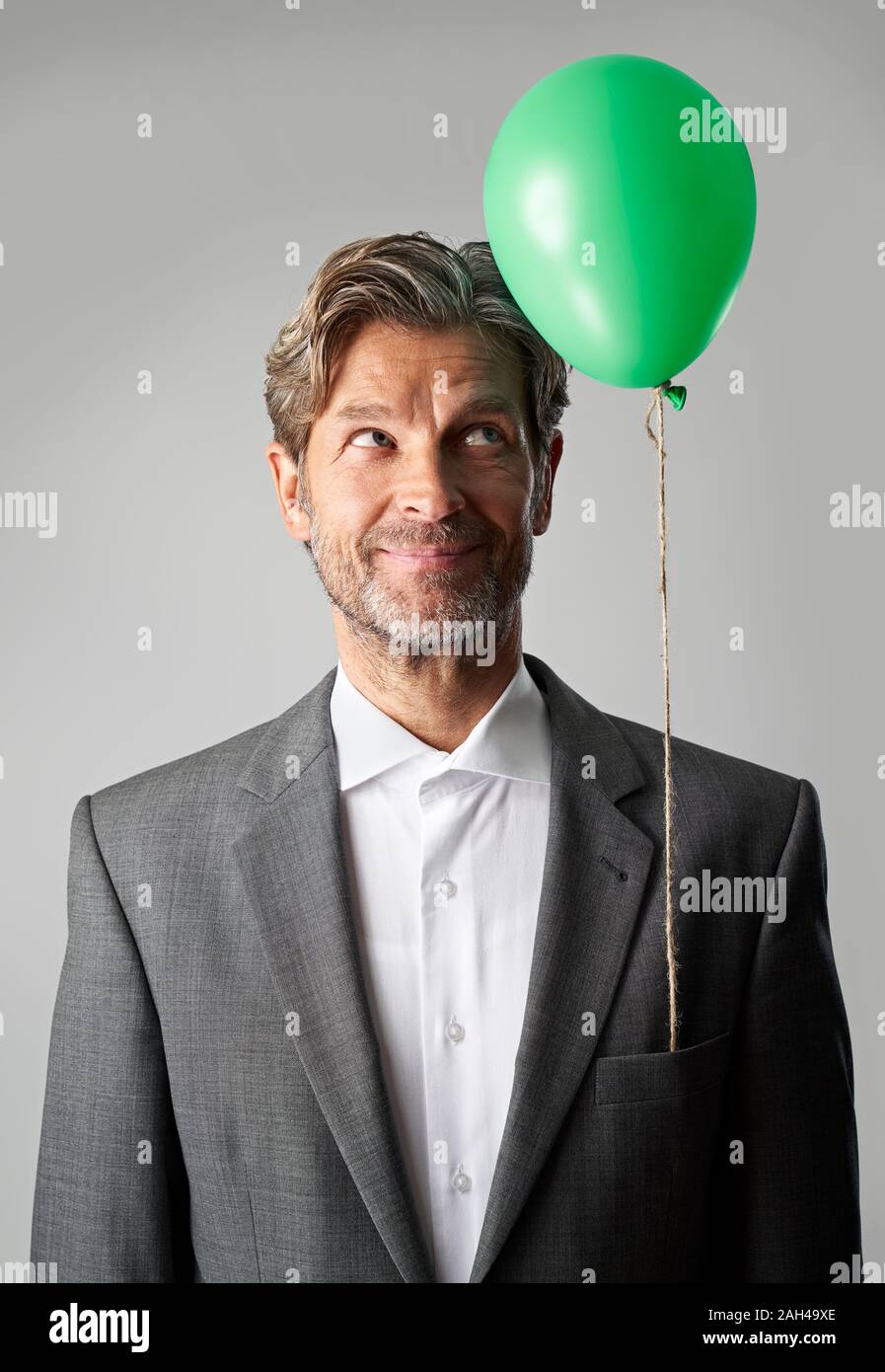 Ritratto di imprenditore sorridente con palloncino verde Foto Stock