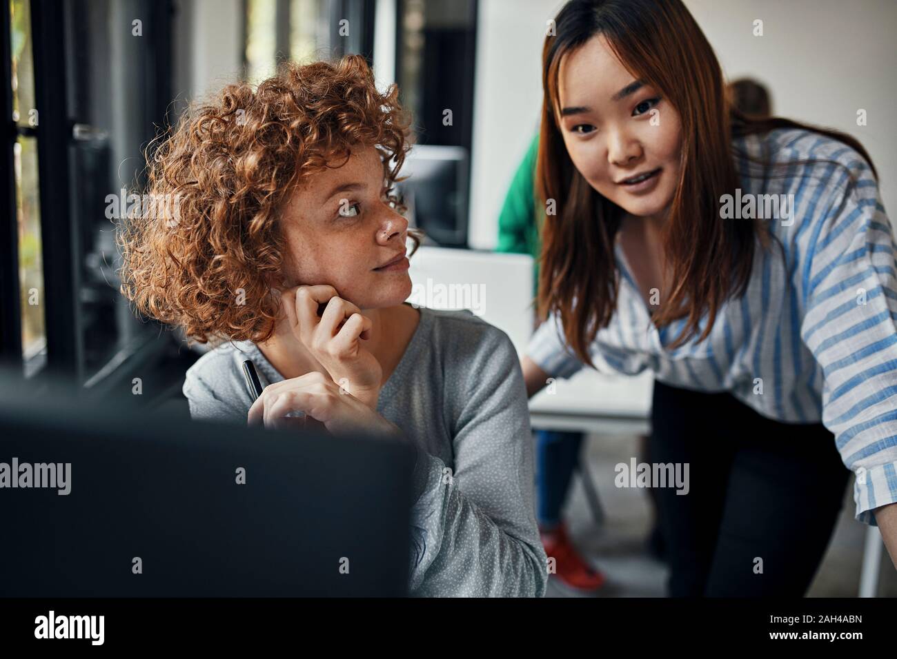 Due imprenditrici che lavorano insieme alla scrivania in ufficio Foto Stock
