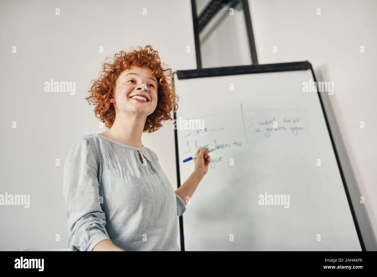 Sorridente imprenditrice portando una presentazione alla lavagna a fogli mobili in sala conferenze Foto Stock