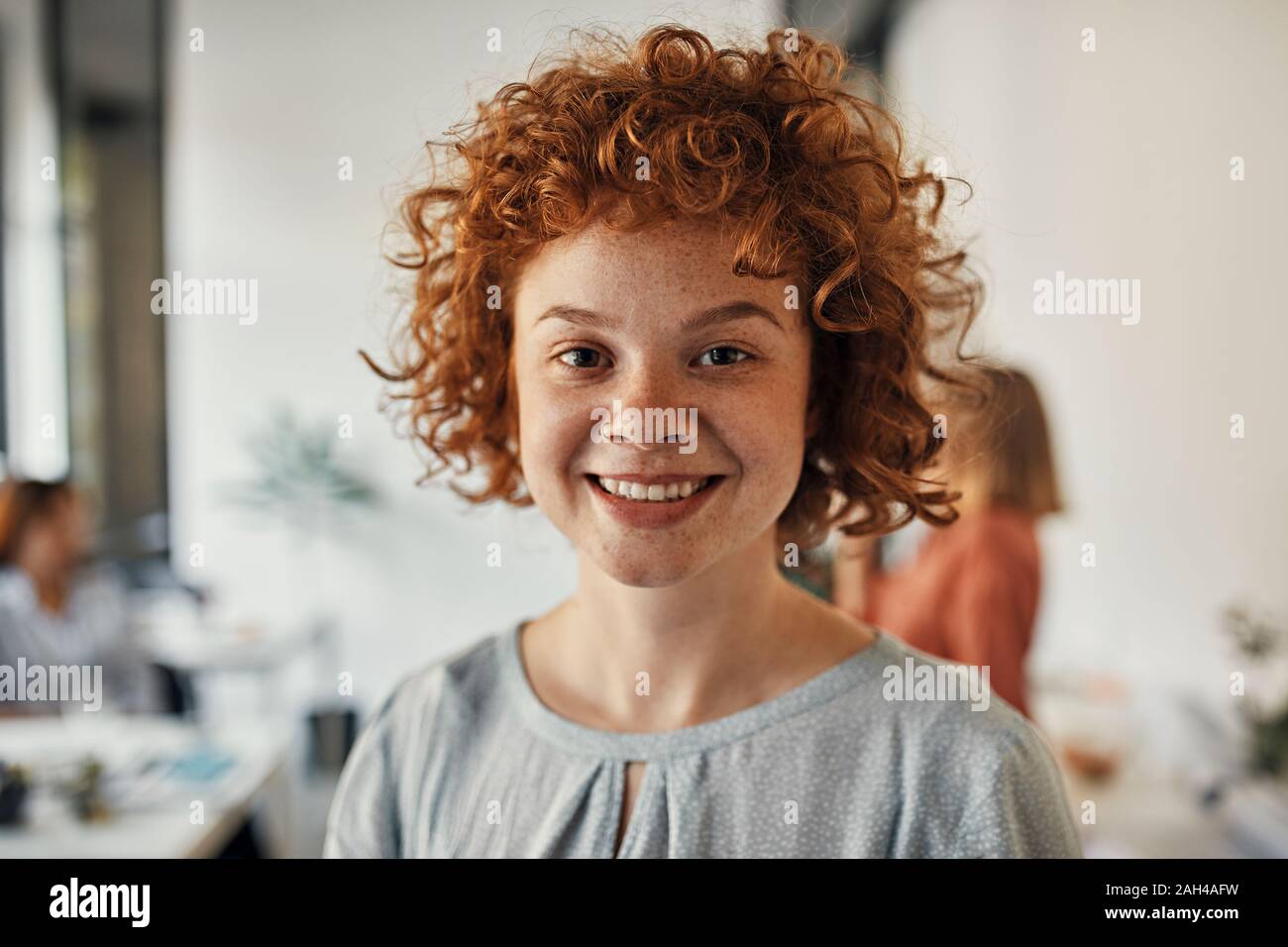 Ritratto di un sorridente redheaded imprenditrice in office Foto Stock