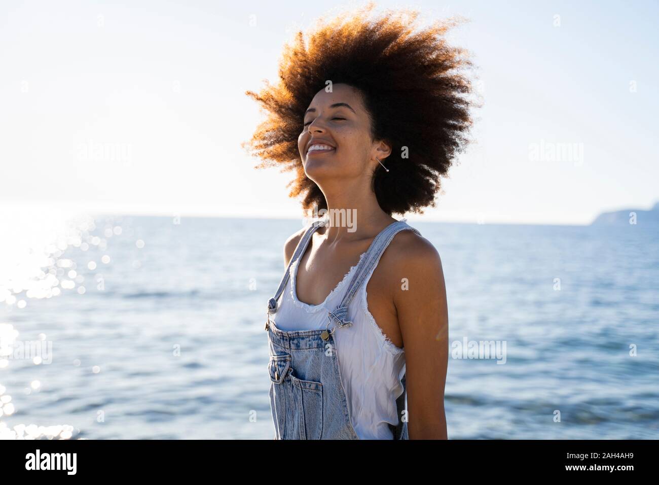 Giovane donna sorridente sulla spiaggia Foto Stock