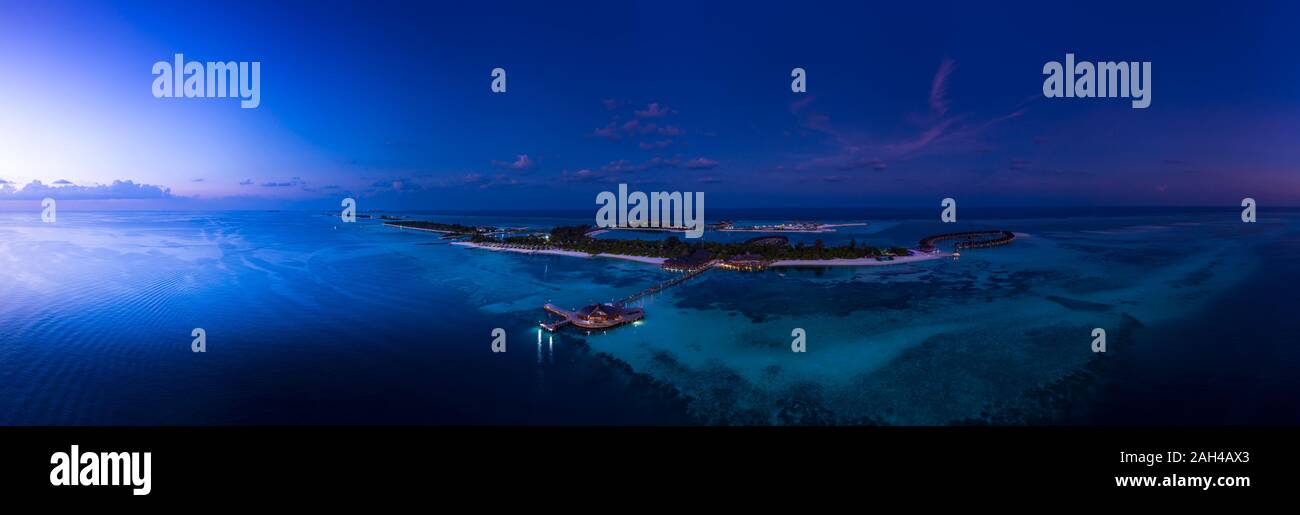 Maldive, South Male Atoll, Maldive Olhuveli laguna con bungalow sulla spiaggia al tramonto Foto Stock