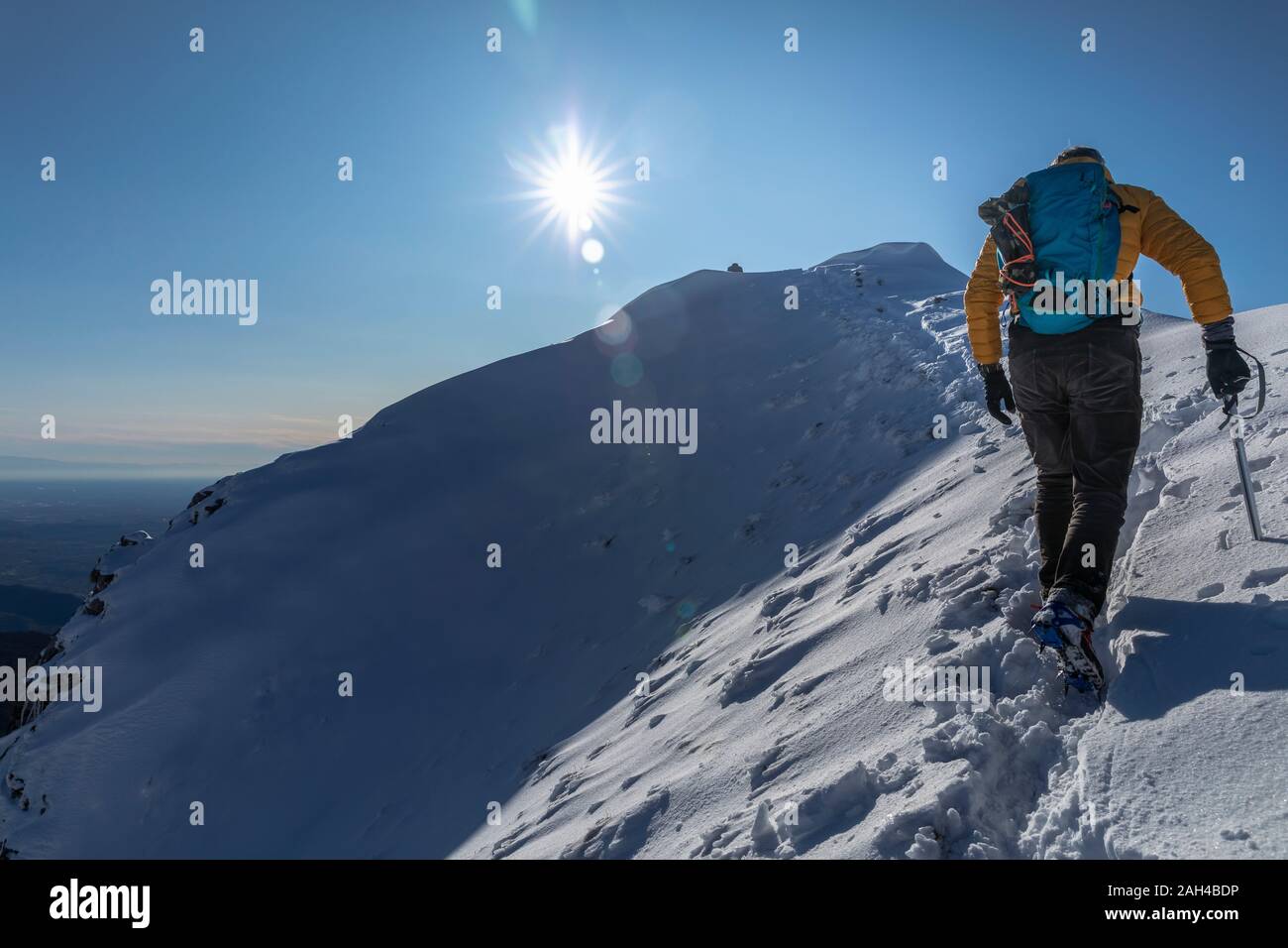 Alpinista escursionismo sulla montagna innevata, Lecco, Italia Foto Stock