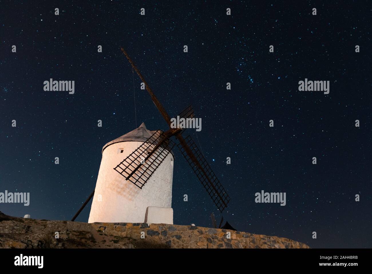 Spagna, provincia di Toledo, Consuegra, antico mulino a vento in piedi contro il cielo stellato Foto Stock