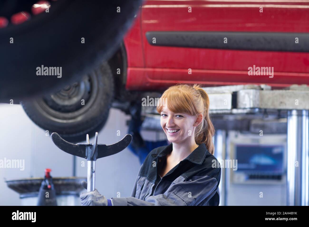 Donna sorridente meccanico auto nel garage di riparazione Foto Stock