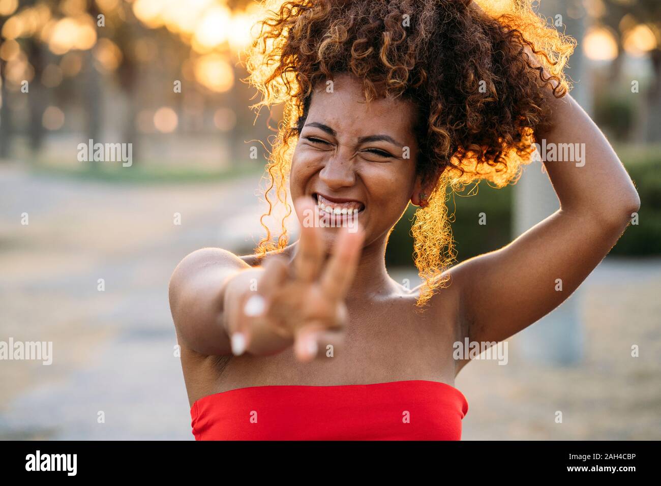 Giovane donna felice esprimenti V gesto con le dita Foto Stock