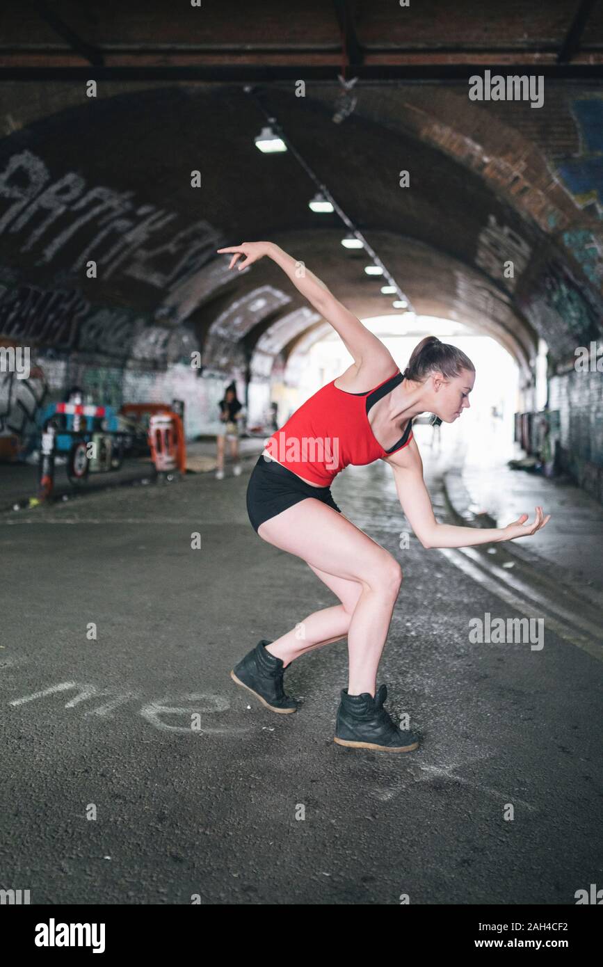 Giovane donna danze ad un sottopassaggio in città Foto Stock