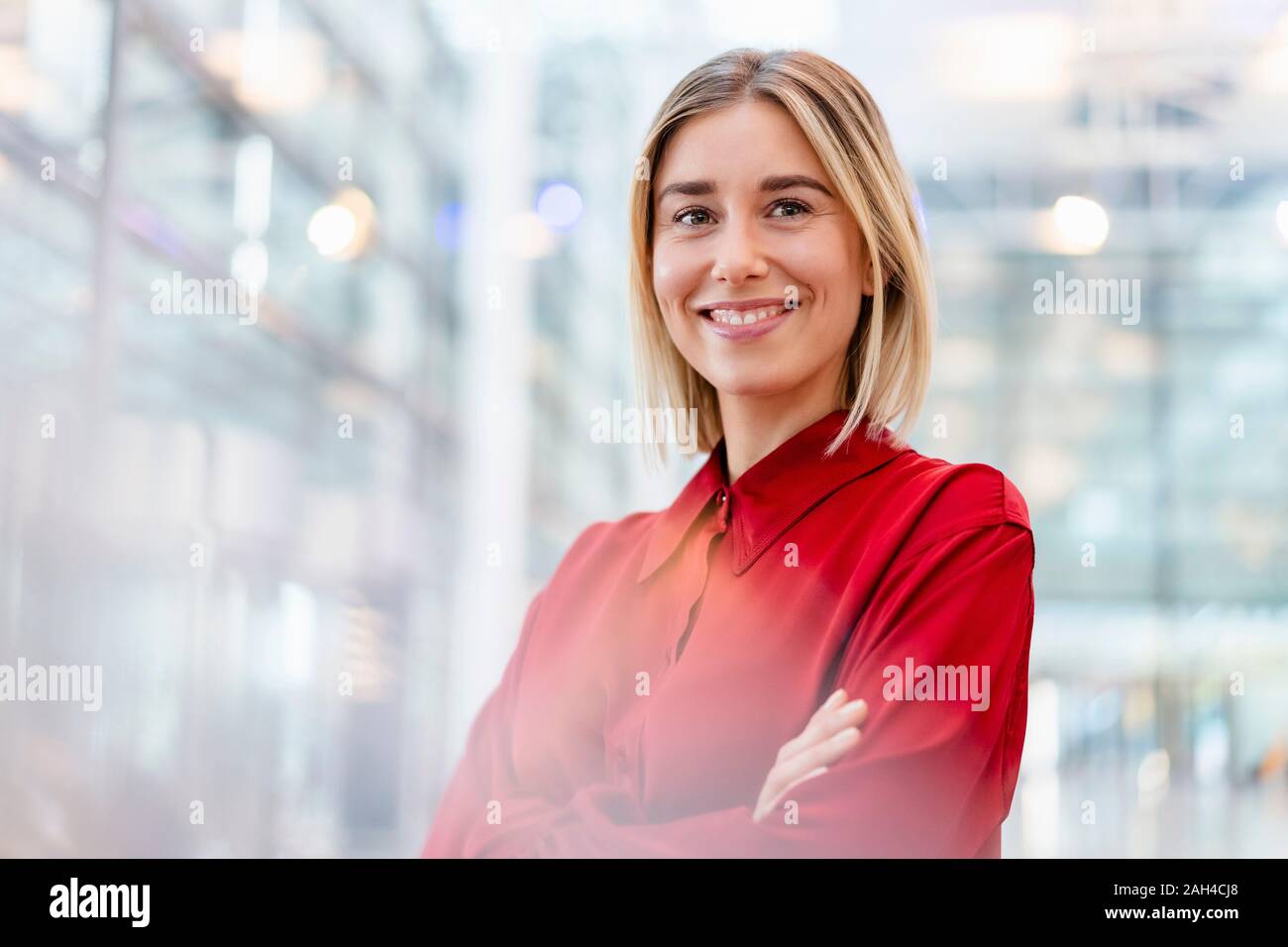 Ritratto di un fiducioso giovane imprenditrice indossando maglietta rossa Foto Stock